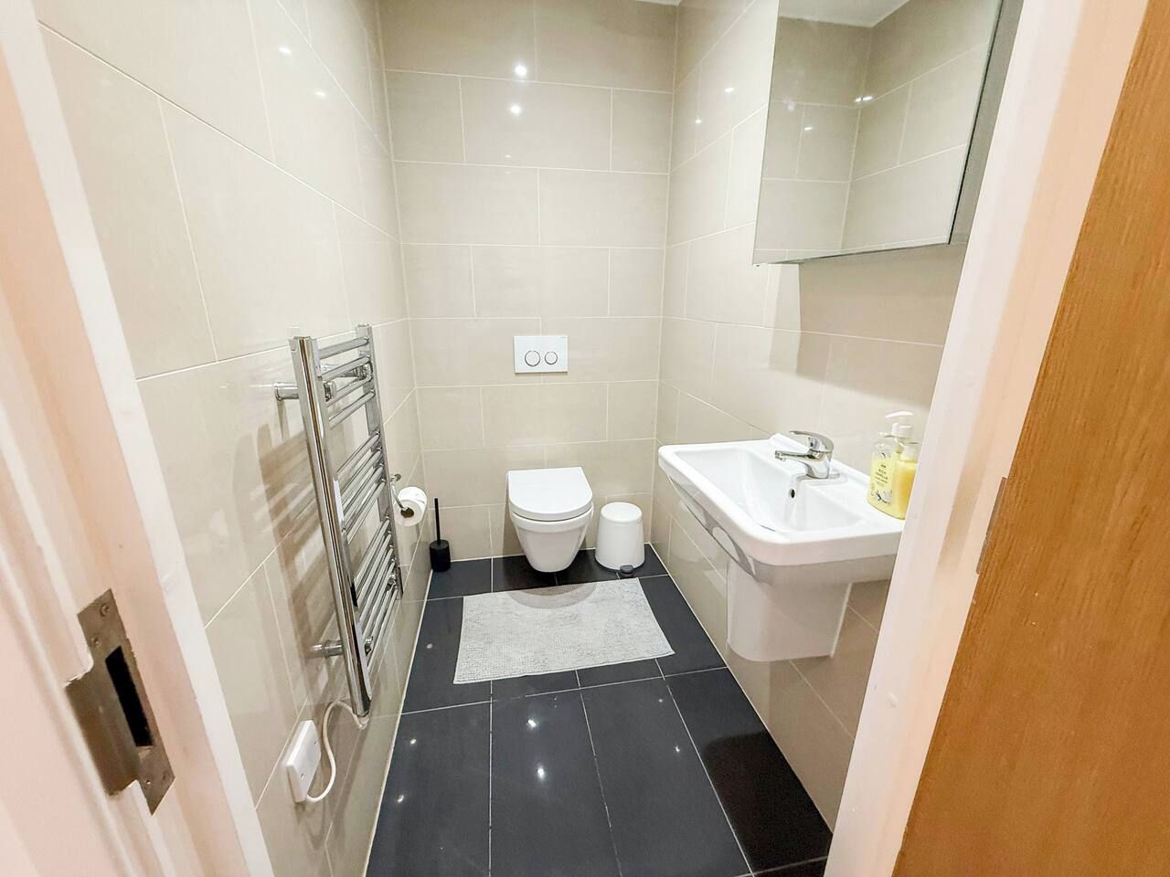 A modern bathroom with a toilet, sink, and mirror.