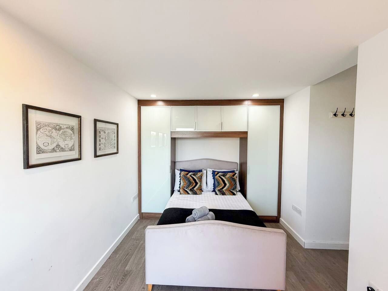 A bedroom with a bed, a bench, and a wardrobe.
