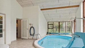 Ein Swimmingpool mit blauem Stuhl, einer Tür und einem Schlauch an der Wand.