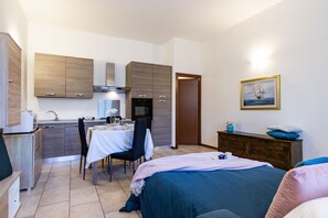 A modern hotel room with a kitchen area, a dining table, and a bed. - [Sweet Arona] Beautiful Apartment, Netflix - Wi-Fi (Arona)