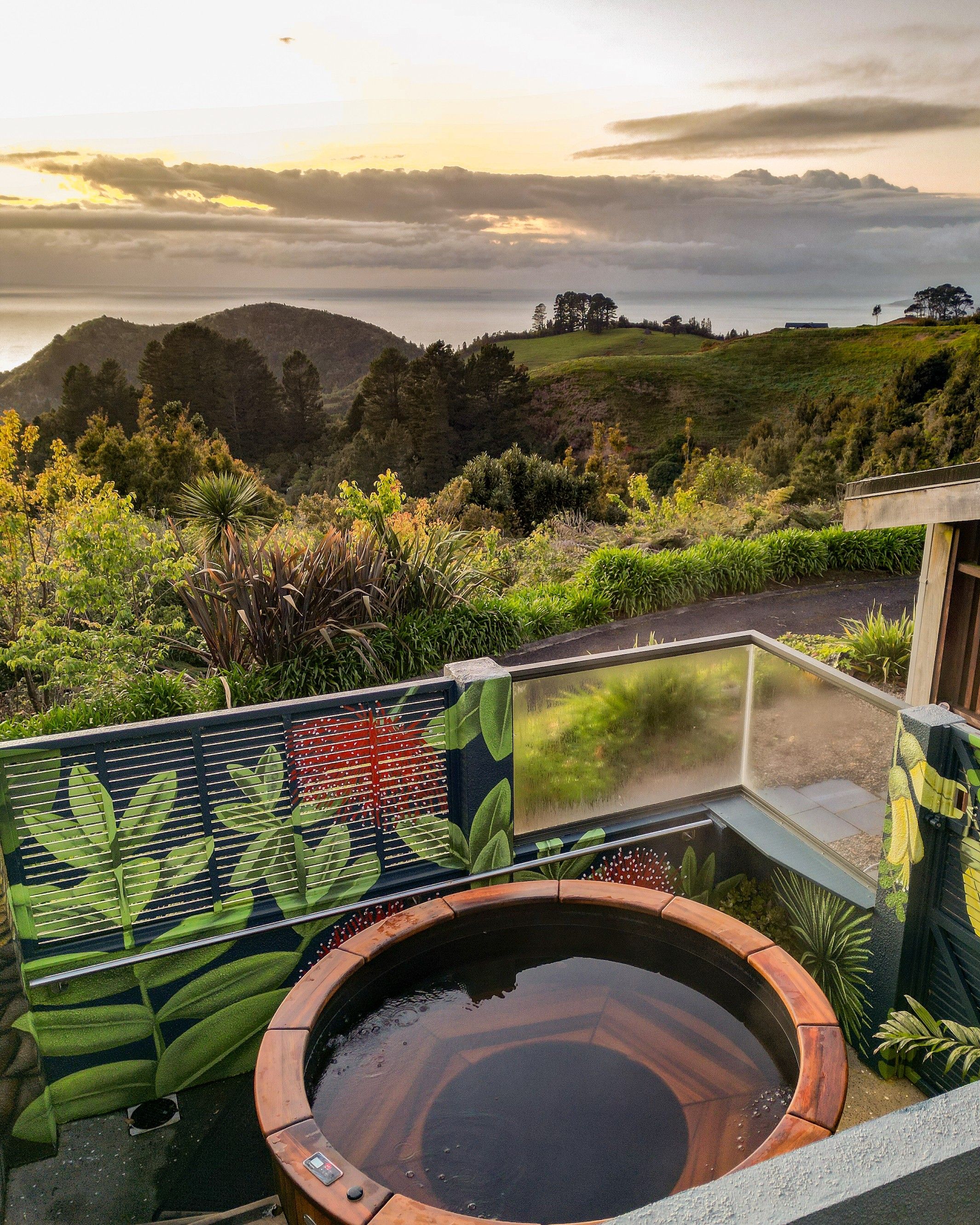 A hot tub with a view of a mountainous landscape and a body of water in the distance.