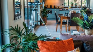Un salon moderne avec un canapé en cuir, un coin repas et une cuisine en arrière-plan.