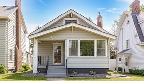 A single-story house with a front porch, a chimney, and a small front yard. - Light and Bright Northland (Superior)