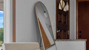 A wooden chair with a cushion, a surfboard leaning against a wall, and a door with a mirror. - Group Getaway Retreat: Hot tub, Game Room, Cinema & Firepit (Milwaukee)
