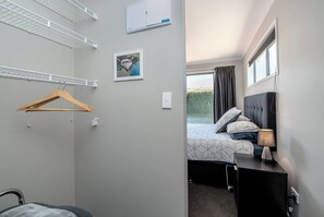 Ein Hotelzimmer mit Bett, Nachttischlampe und einem Vorhangfenster.