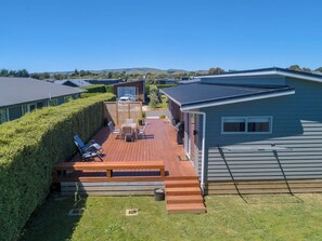 Une terrasse dotée de mobilier d’extérieur, d’un espace barbecue et offrant une vue sur le paysage environnant.