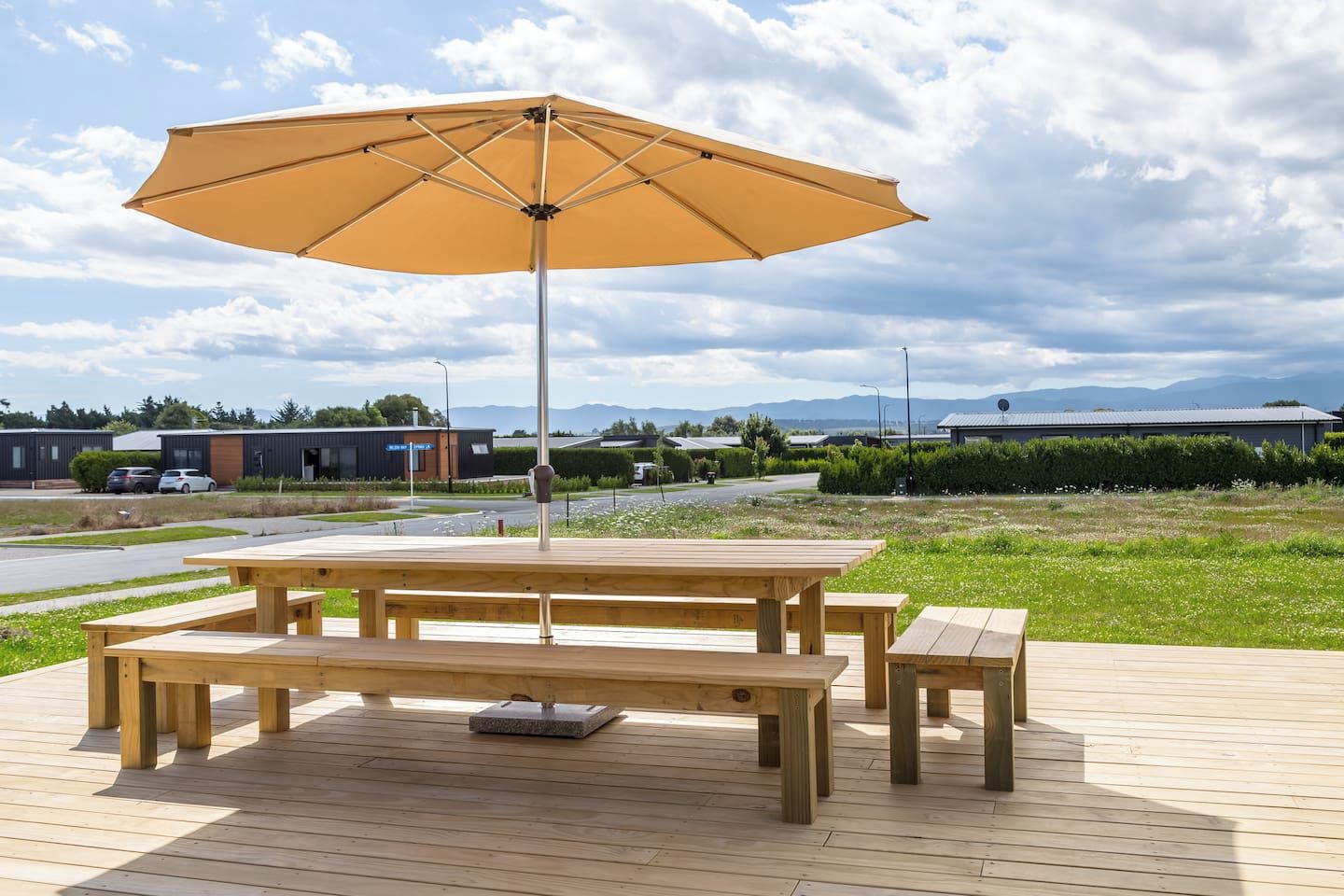 A wooden deck with a picnic table and an umbrella.