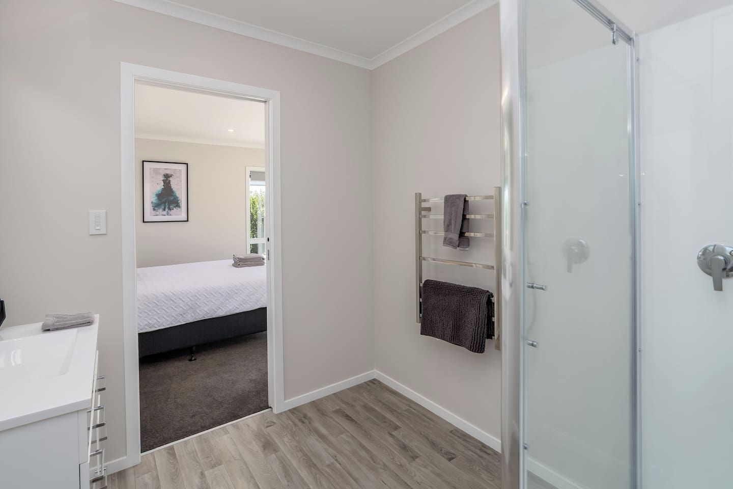 A modern bathroom with a shower, a toilet, and a sink.