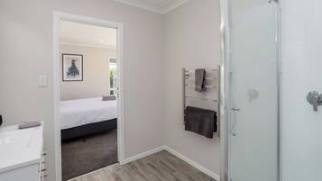 A modern bathroom with a shower, a toilet, and a sink.