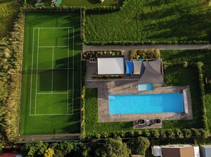 An aerial view of a property with a tennis court, a swimming pool, and a covered patio area. - Burgundy Place, Martinborough (Martinborough)