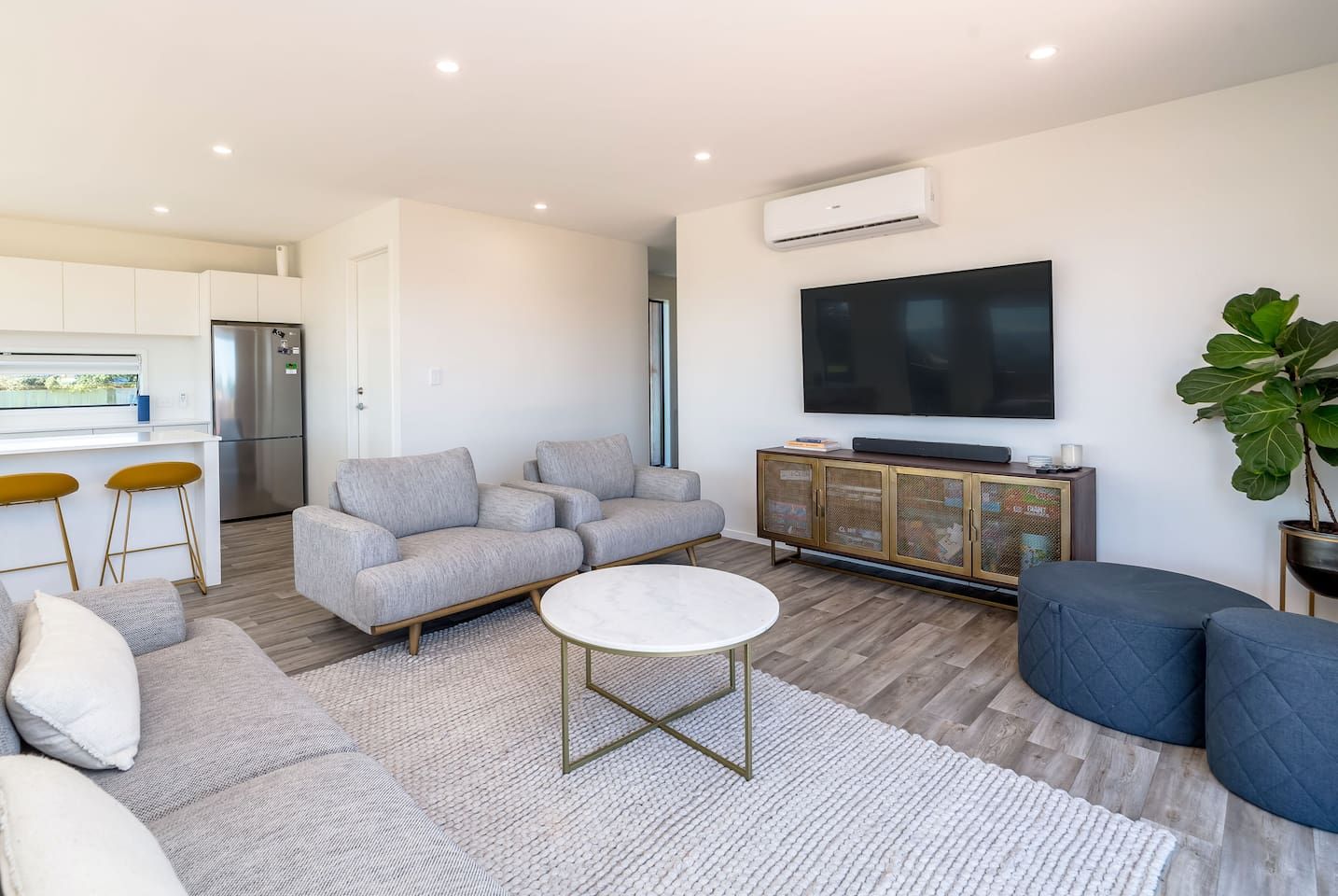 A modern living room with a sofa, a coffee table, and a TV.