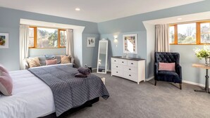 A bedroom with a bed, dresser, chair, and a mirror. - Longbush Estate, Gladstone (Longbush)
