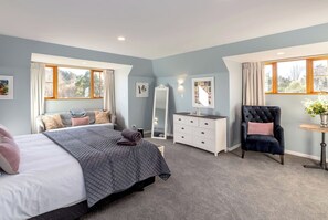 Une chambre à coucher avec un lit, une commode, une chaise et un miroir.