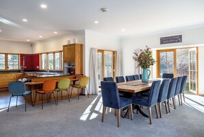 A modern kitchen with wooden cabinets and a dining area with a large table and chairs.