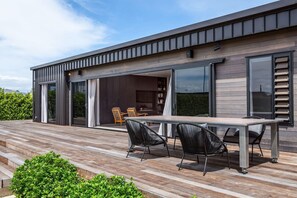 A modern house with a wooden deck, outdoor seating, and large windows. - Relax on the Deck, Martinborough (Martinborough)
