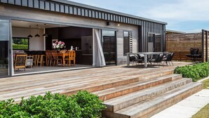 Une maison moderne dotée d’une terrasse, d’un coin repas et d’une cuisine.