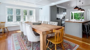 A modern kitchen with a wooden island, white cabinetry, and a large window providing natural light.