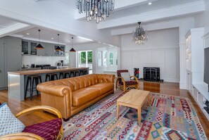 A spacious living room with a leather sofa, a wooden coffee table, and a patterned rug. - The Forest House, Pirinoa (Pirinoa)
