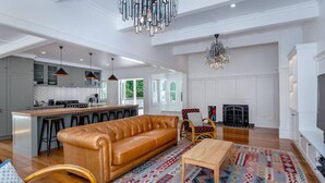 A spacious living room with a leather sofa, a wooden coffee table, and a patterned rug. - The Forest House, Martinborough (Pirinoa)