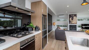 A modern kitchen with a central island, stainless steel appliances, and a view to the outdoors.