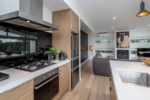 A modern kitchen with a central island, stainless steel appliances, and a view to the outdoors. - Number 35, Martinborough (Martinborough)