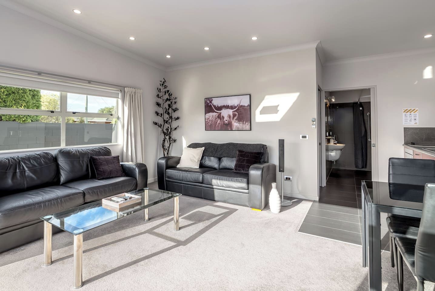 Ein modernes Wohnzimmer mit einer Couch, einem Couchtisch und einem Bild an der Wand.