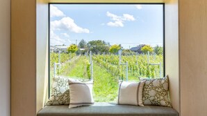 A window seat with a view of a vineyard and houses.