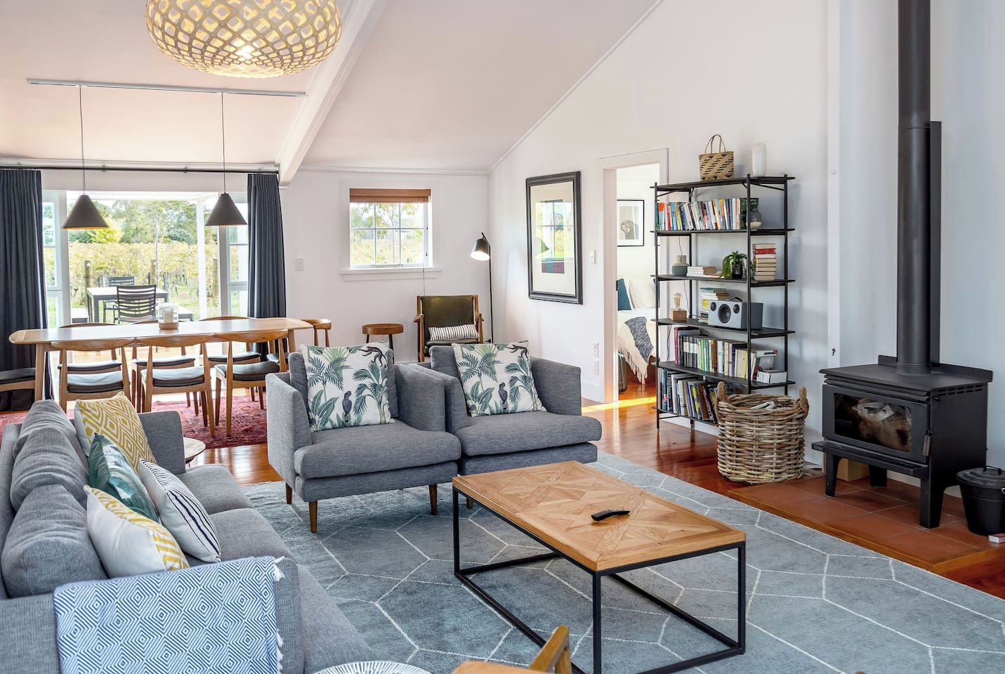 A modern living room with a sofa set, a coffee table, a bookshelf, and a fireplace.