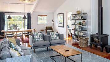A modern living room with a sofa set, a coffee table, a bookshelf, and a fireplace.