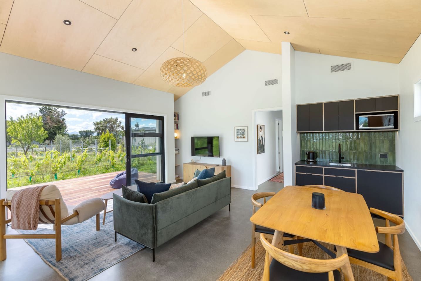 A modern interior with a dining area, sofa, and kitchen.