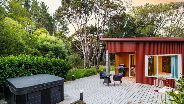 A compact outdoor deck with a hot tub, seating, and a small grill area. - The  Glade, Martinborough (Ruakōkoputuna)