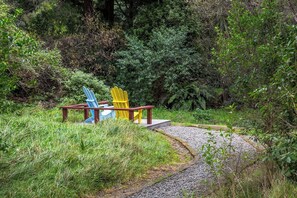 A pathway leading to a seating area with two chairs. - The  Glade, Martinborough (Ruakōkoputuna)