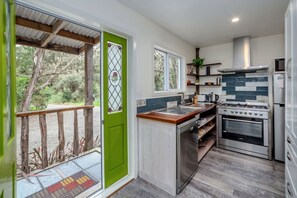 A compact kitchen with a gas stove, oven, and a sink. - The  Glade, Martinborough (Ruakōkoputuna)