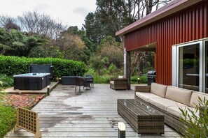 Una terrazza con mobili da esterno, una vasca idromassaggio e un’area barbecue.