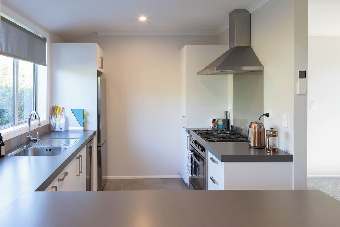 A modern kitchen with stainless steel appliances, a gas stove, and a range hood.