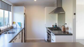 A modern kitchen with stainless steel appliances, a gas stove, and a range hood.