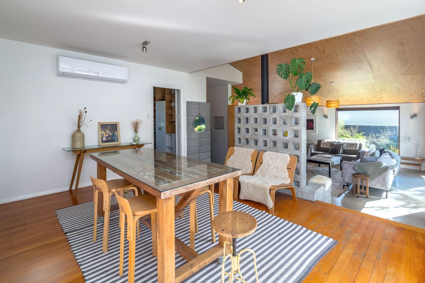 A modern living space with a dining area, seating, and a view of the outdoors.