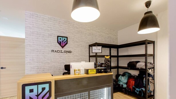 Ein Empfangsschalter mit einem 'Welcome'-Schild, dem Logo von 'RADZONE' und einem Schild für 'Express Check-Out'.