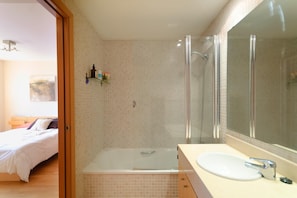 Bathtub, hair dryer, towels, toilet paper