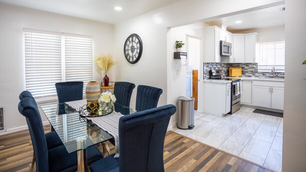 A modern kitchen with white cabinets, a microwave, and a sink. - The Yuma White Modern Pool/Pet friendly Home (Yuma)