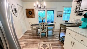 A kitchen with a central island, a refrigerator, and a dining table with chairs. - Paradise is waiting for you! Minutes away from St. Simons, Jekyll, Golf & FLETC! (Brunswick)