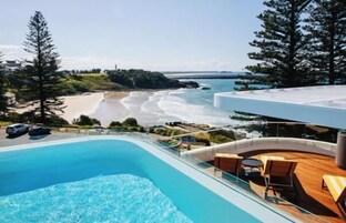 Una piscina al aire libre, sillones reclinables de piscina