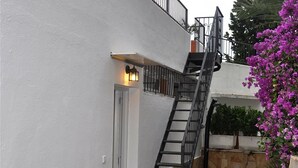 A white building with a black metal staircase leading to a balcony. - Holiday Villa in Tarragona with Open Terrace, Garden & Wi-Fi (Tarragona)