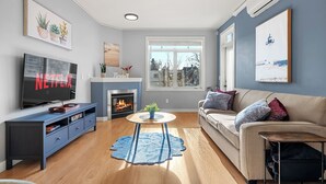 Ein Wohnzimmer mit Kamin, Fernseher und einer Couch.