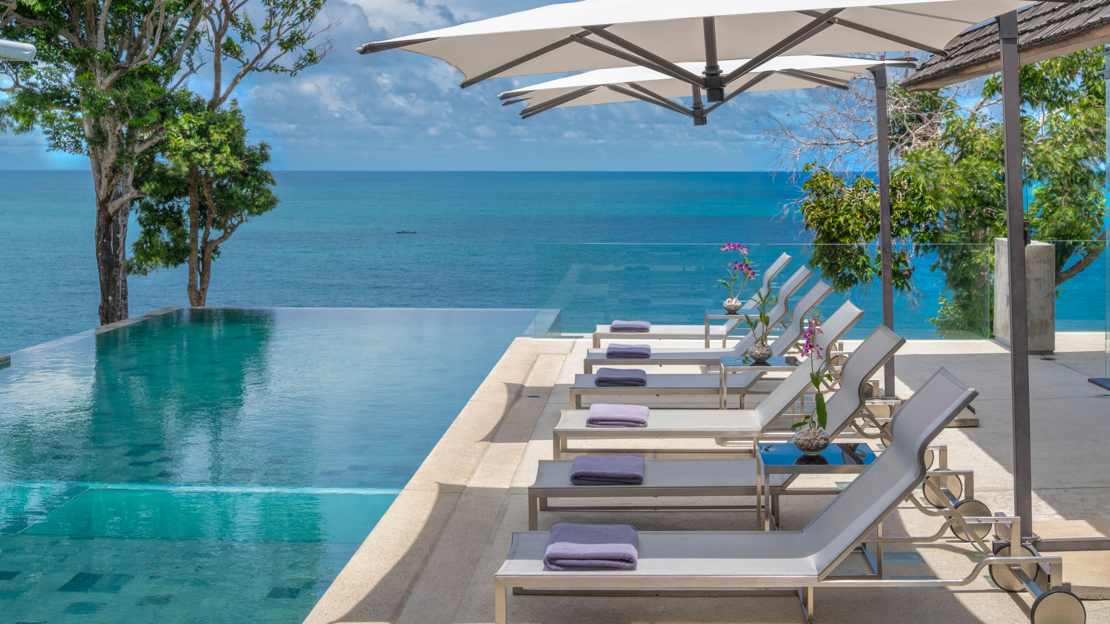 Una piscina al aire libre, sombrillas, sillones reclinables de piscina