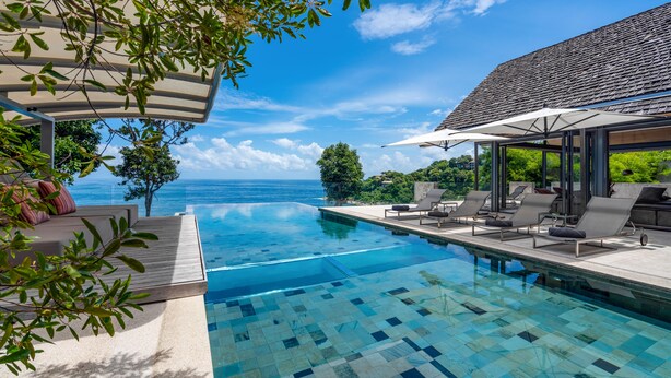 An infinity pool with a clear view of the ocean, lounge chairs, and a covered seating area. - Villa Saengootsa (Kamala)