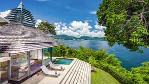 A modern villa with a glass-enclosed balcony, a pool, and a view of a lake and mountains. - Villa Saengootsa (Kamala)