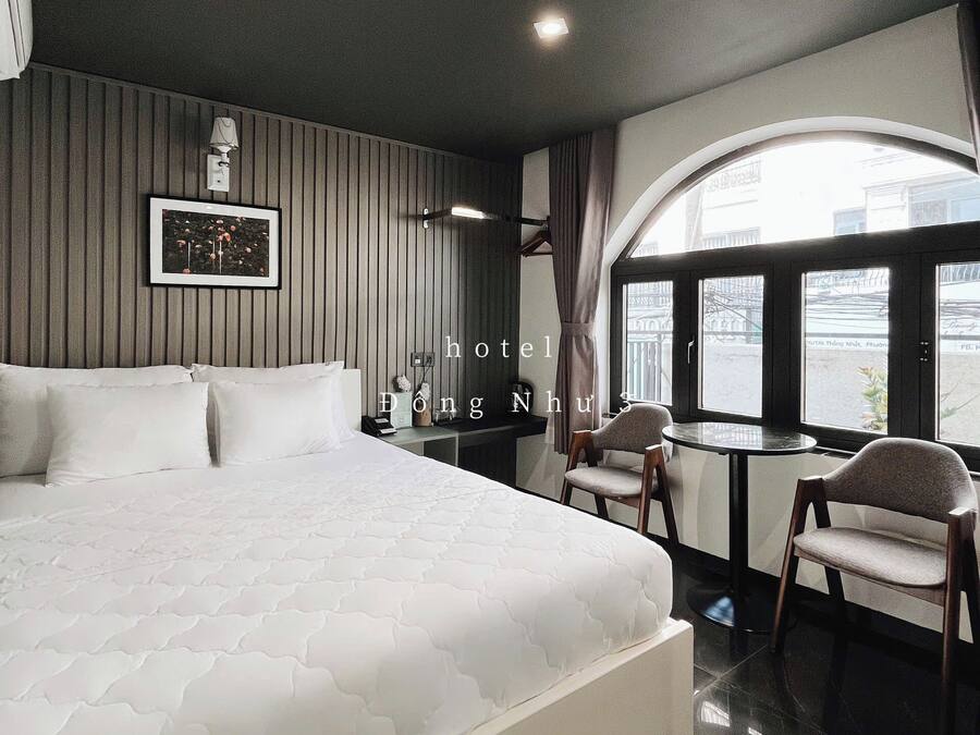 Une chambre d’hôtel avec un grand lit, un bureau et une vue sur l’extérieur.