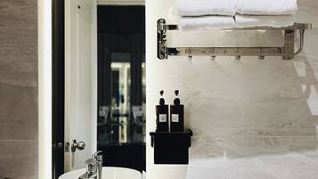 Un baño moderno con un lavamanos blanco, un inodoro y un perchero para toallas.