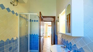 A bathroom with a shower, sink, and mirror.